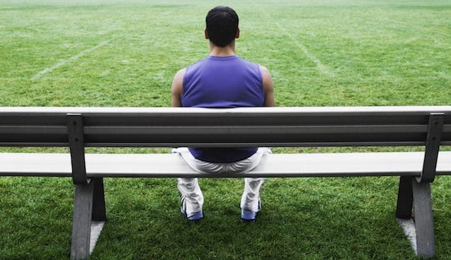 Male athlete sitting on bench